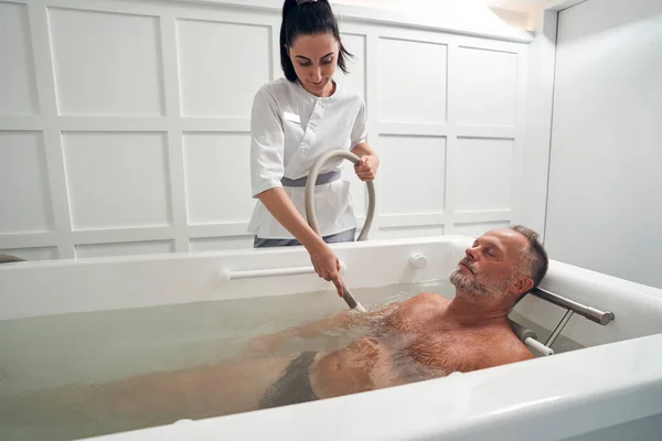 Mannelijke persoon die hydrotherapie procedure in spa salon — Stockfoto