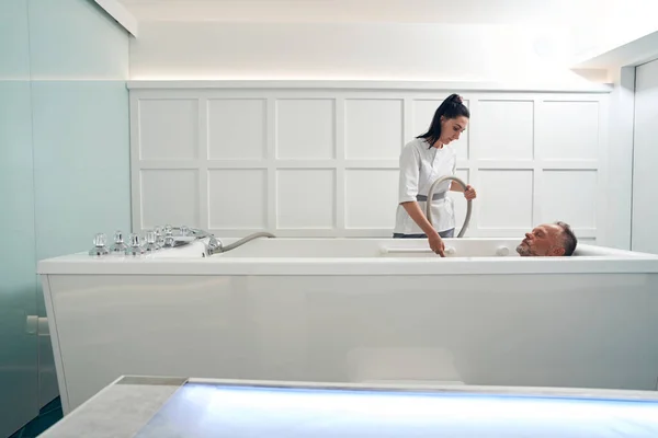 Esteticista realizando hidromasaje en salón de spa — Foto de Stock