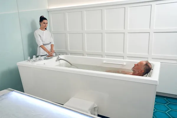 Homem tomando banho revitalizante no centro de bem-estar spa — Fotografia de Stock