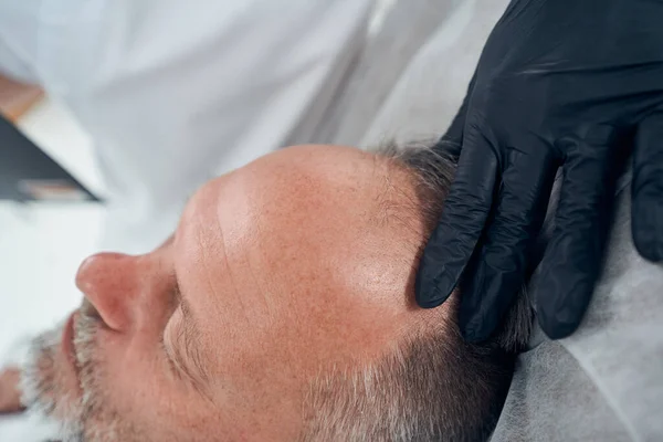 수술 클리닉에서 남자의 머리를 진찰하고 있는 의사 — 스톡 사진