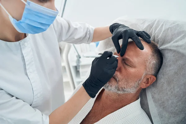 Чоловік, який має процедуру сканування в косметологічній клініці — стокове фото