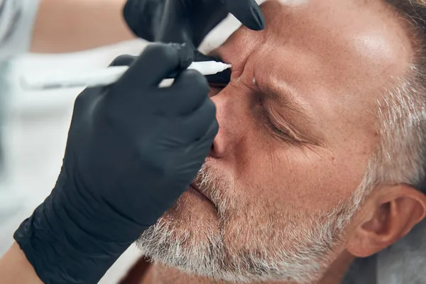 Мужчина, проходящий процедуру очищения кожи в косметологической клинике — стоковое фото