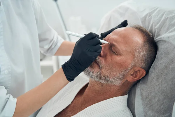 Persona di sesso maschile sottoposta a procedura di pulizia della pelle in clinica di cosmetologia — Foto Stock