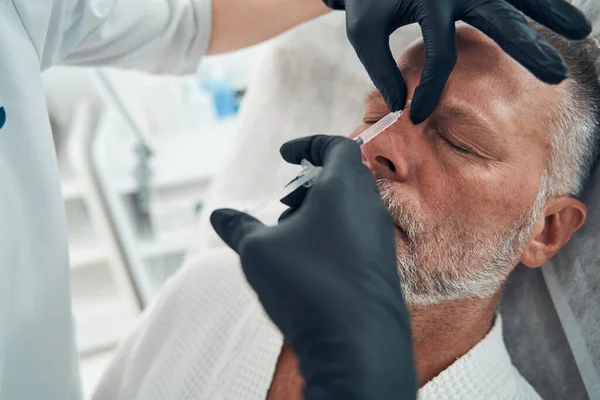 Uomo che riceve l'iniezione cosmetica al centro benessere — Foto Stock