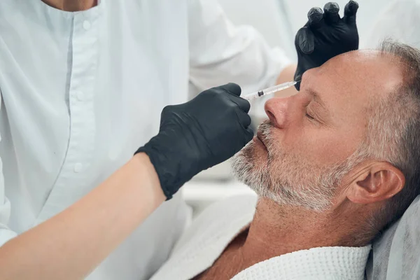 Medico cosmetologo fare iniezione in faccia maschile — Foto Stock