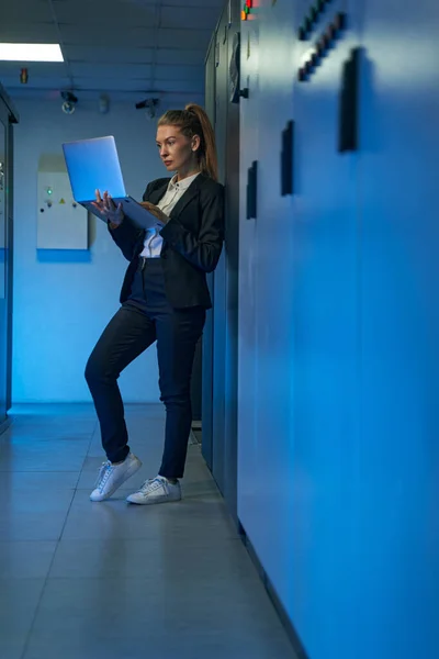 Técnico feminino usando laptop na sala do servidor — Fotografia de Stock