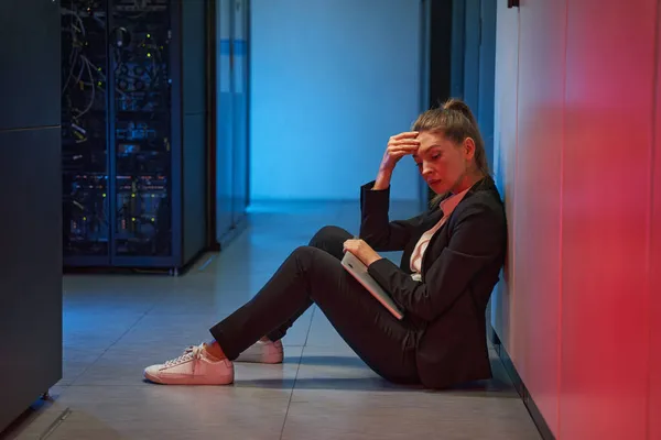 Donna depressa seduta accanto al pavimento dei server del data center — Foto Stock
