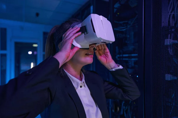 Erstaunte Frau mit VR-Headset im Serverraum — Stockfoto
