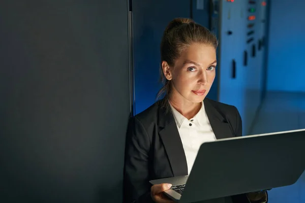 Frau führt Wartungsarbeiten an Servern mit Laptop im Rechenzentrum durch — Stockfoto