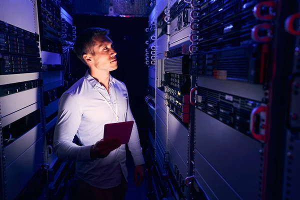 Empleado del centro de datos inspeccionando equipos en sala de servidores — Foto de Stock