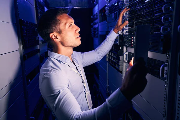 Administrador del sistema inspeccionando hardware de almacenamiento en la sala de servidores — Foto de Stock