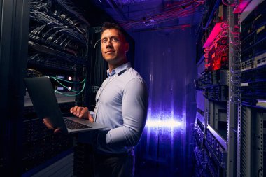 Memnun genç sistem yöneticisi sunucu performansını izliyor