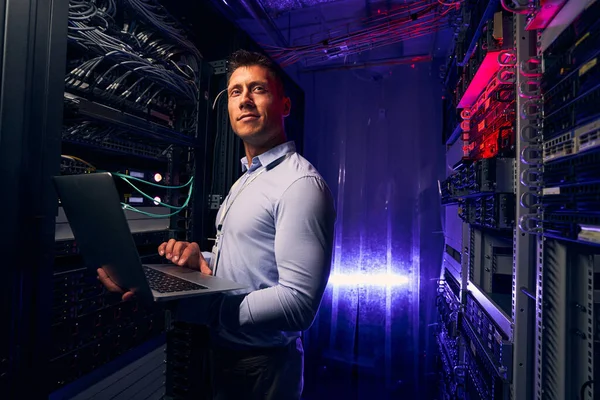 Zufriedener junger Systemadministrator, der die Leistung des Servers überwacht — Stockfoto