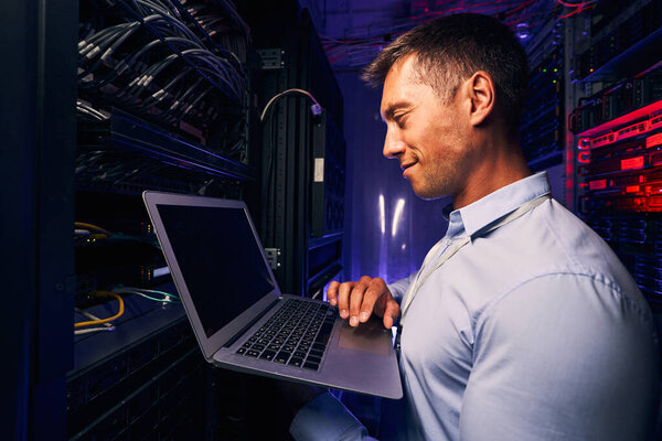 Smiling pleased system administrator checking server performance