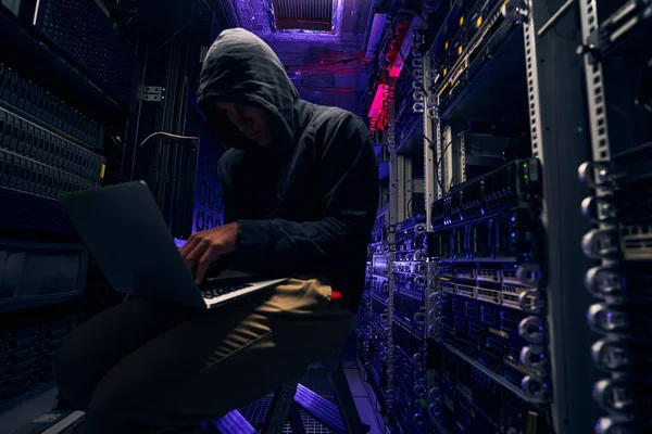 Pelaku cyber berpengalaman mendapatkan akses tanpa izin ke data menggunakan laptopnya. — Stok Foto