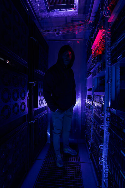 Tranquil Caucasian male hacker in dark server room