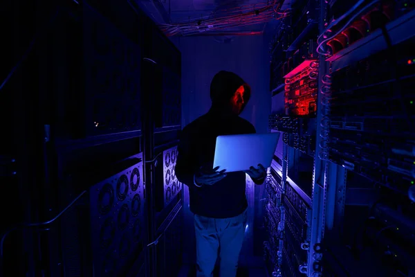 Hacker menatap pada peralatan jaringan pusat data — Stok Foto