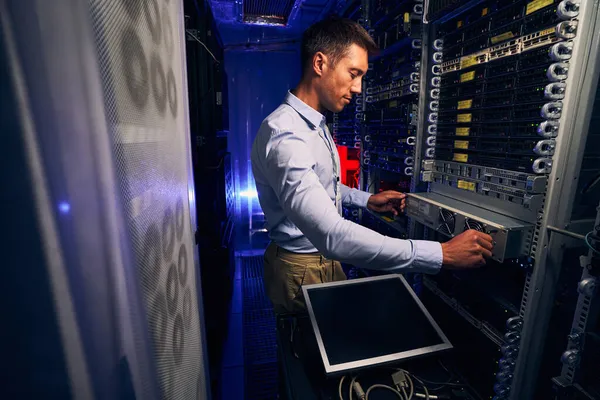 Erfahrener männlicher Ingenieur arbeitet im Serverraum — Stockfoto