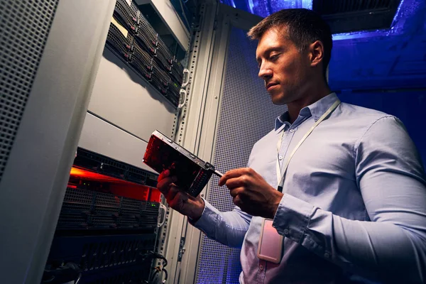 Ingeniero de centro de datos inspeccionando nueva unidad de disco duro — Foto de Stock