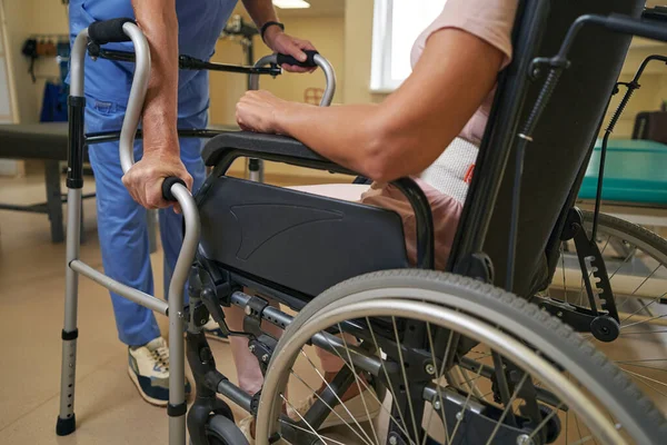 Felç geçiren kadın rehabilitasyon merkezinde Walker 'ı kullanıyor.