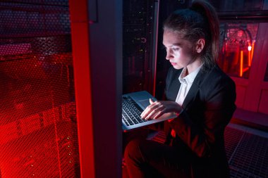 Sunucuyu analiz etmek için dizüstü bilgisayar kullanan kadın teknisyen