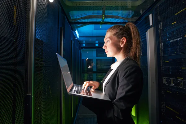 Adult woman network engineer in server room