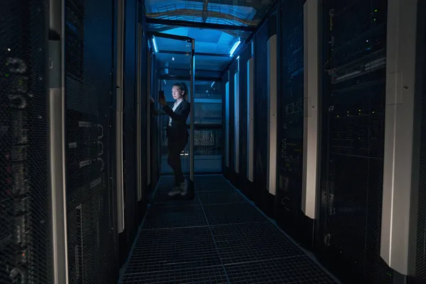 Caucasian woman engineer in server room at modern data center