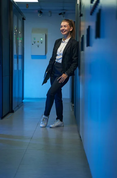 Привабливий жіночий технік, що стоїть в серверній кімнаті — стокове фото