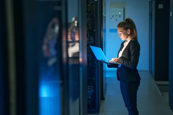 Ingénieur féminin travaillant dans la salle des serveurs du centre de données moderne — Photo