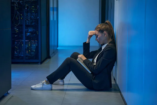 Vrouwelijke technicus voelt druk in serverruimte — Stockfoto