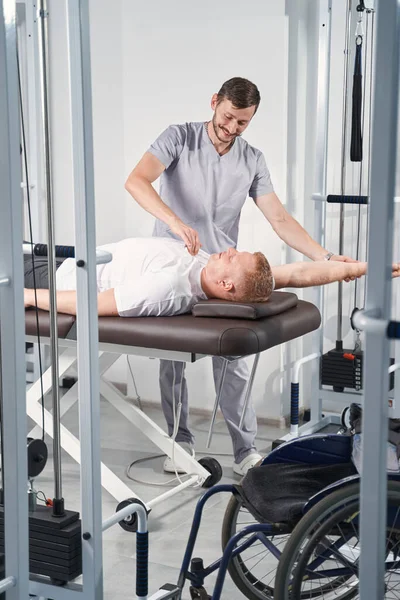 Chiropractor treats shoulder joint mobility of man on massage table — Stock Photo, Image