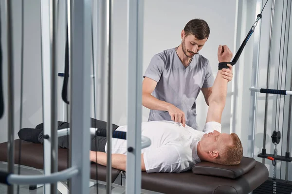 Mann übt mit Physiotherapeutin an Dekompressionstrainerin — Stockfoto