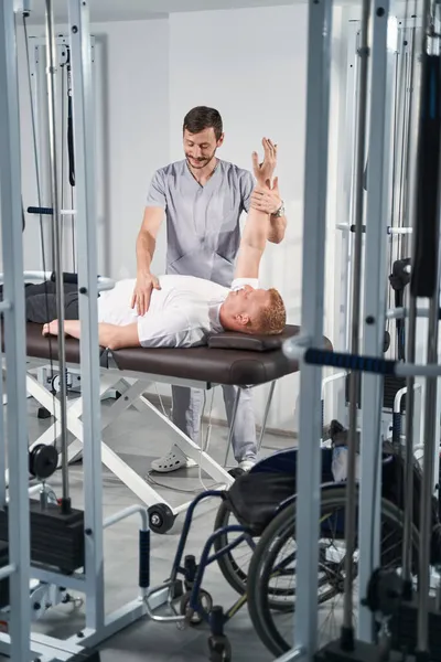 Young physioterapist man make arm rehab treatment to male patient — Stock Photo, Image