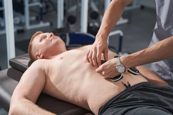 Close up electrostimulator on man stomach. Myostimulation therapy — Stock Photo, Image
