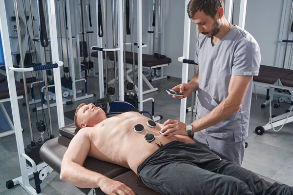 Elektrostimulator Massage des Männerbauchs mit Therapeut. Reha — Stockfoto