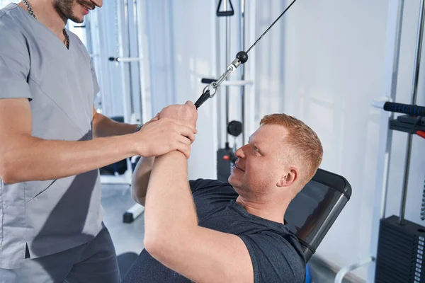 Rehab therapie voor patiënten met een handicap. Jongeman op stretch machine — Stockfoto