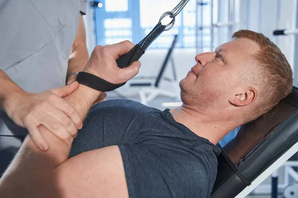 Close-up sterke man training hand met verstuiking in de sportschool van rehab center — Stockfoto