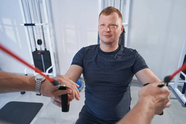 Man patiënt doet oefeningen van ligament verstuiking in fysiotherapie kliniek — Stockfoto