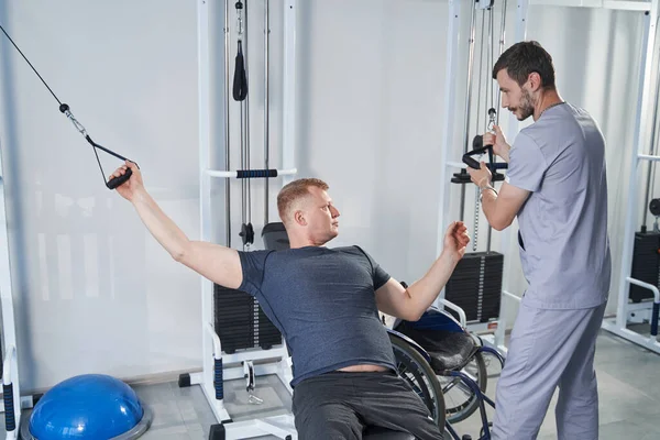 Rehabilitasyon salonunda engelli eğitimi almış genç bir adam. Özürlü hasta.