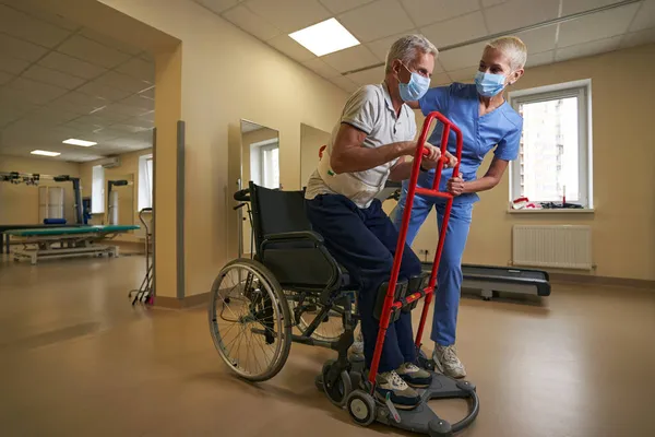 Физиотерапевт помогает пациенту с инсультом в реабилитационном центре — стоковое фото