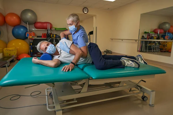 Paciente con accidente cerebrovascular que realiza ejercicios en el centro de rehabilitación en la sala de terapia — Foto de Stock