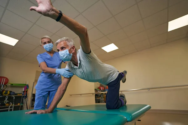 Pflegende Physiotherapeutin hilft Schlaganfallopfer in Reha-Zentrum — Stockfoto