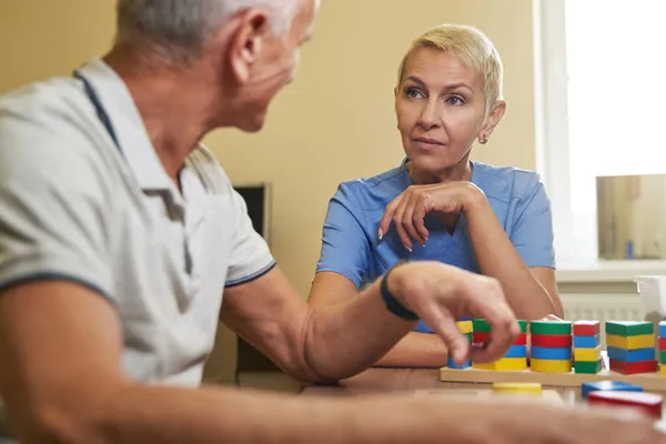 Fysiotherapeut consulteert beroerte patiënt in revalidatiecentrum — Stockfoto