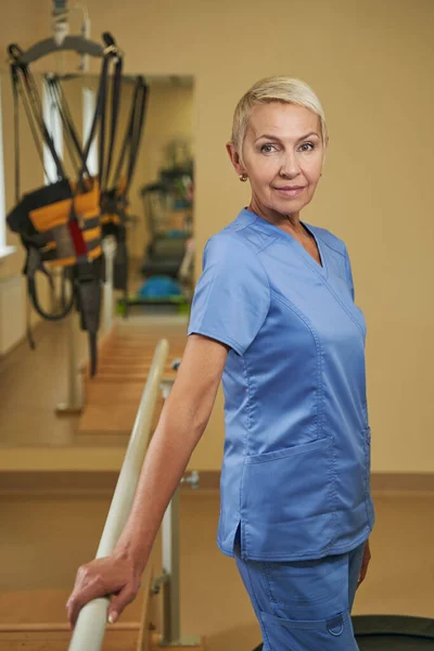 Επαγγελματική φυσιοθεραπεύτρια στέκεται στο κέντρο αποκατάστασης — Φωτογραφία Αρχείου