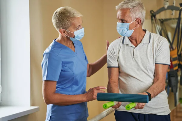 Physical therapist helping stroke victim in rehab center — Stock Photo, Image