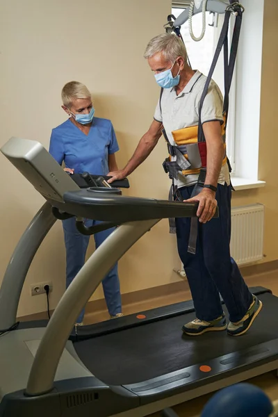 Starší pacient dělá cvičení během rehabilitace v lékařském středisku — Stock fotografie