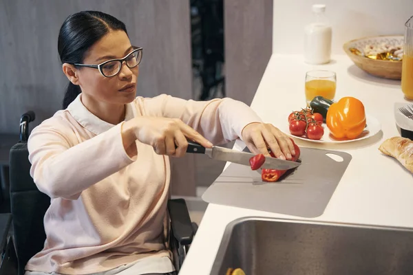 Елегантна жінка з інвалідністю робить салат вдома — стокове фото
