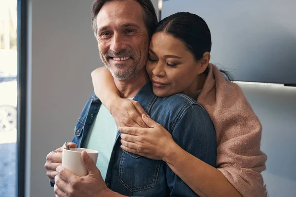 Delighted volwassen man knuffelen met vrouw thuis — Stockfoto