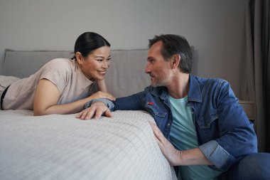 Mutlu evli olgun çift yatak odasında iletişim kuruyor.