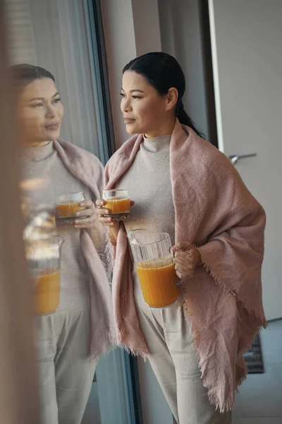 Calma mujer asiática bebiendo jugo en casa —  Fotos de Stock